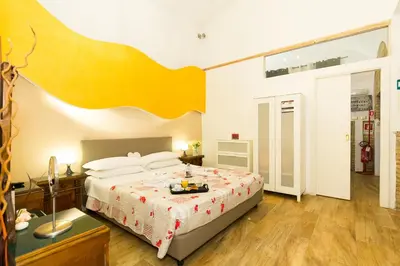 a bedroom with a large bed with a yellow headboard at Nerva Accommodation Cavour in Rome