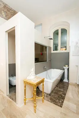 a white bathroom with a tub and a sink at Nerva Accommodation Cavour in Rome