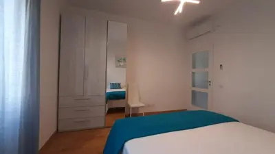 a white bedroom with a bed and a closet at Casa Maloia in Rome