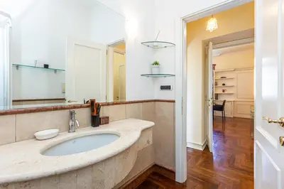 a bathroom with a sink and a mirror at Baccina Apartment by Rental in Rome in Rome