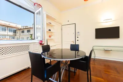 a glass table and chairs in a room with a window at Baccina Apartment by Rental in Rome in Rome