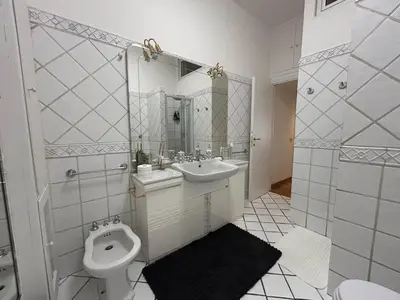 a white bathroom with a toilet and a sink at Tiziano House by Ghor in Rome