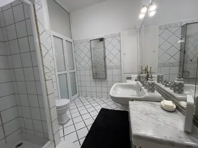 a white bathroom with a sink and a toilet at Tiziano House by Ghor in Rome