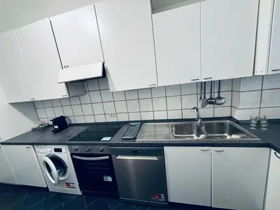 a kitchen with white cabinets and a sink and a dishwasher at Tiziano House by Ghor in Rome
