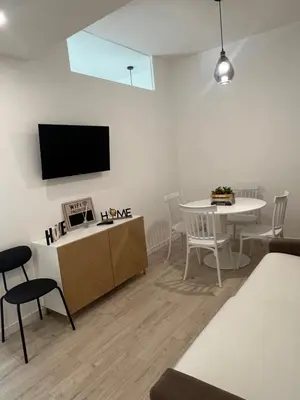 a living room with a table and a tv on the wall at CAFE Balduina in Rome