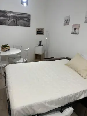 a bedroom with a bed and a desk and a table with chairs at CAFE Balduina in Rome