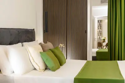 a bedroom with a bed with green and white pillows at Eden Luxury Apartment in Rome