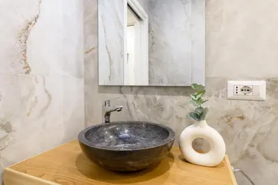 a bathroom with a black bowl sink and a vase at Eden Luxury Apartment in Rome