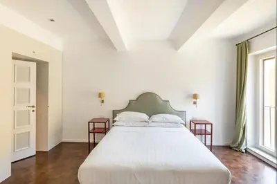 a bedroom with a large white bed with two tables at Residenza Torre Vecchiarelli - apt 4 in Rome