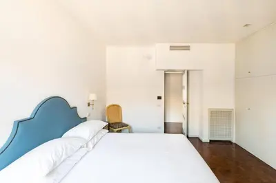 a bedroom with a large bed with a blue headboard at Residenza Torre Vecchiarelli - apt 4 in Rome