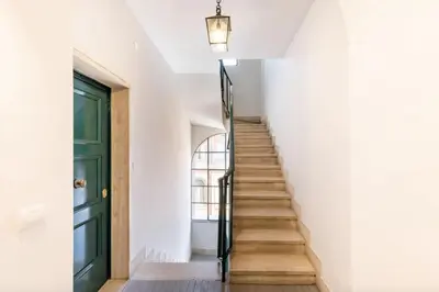 a stairway with a green door and white walls at Residenza Torre Vecchiarelli - apt 4 in Rome
