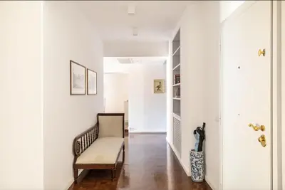 a living room with a bench and a hallway with white walls at Residenza Torre Vecchiarelli - apt 4 in Rome