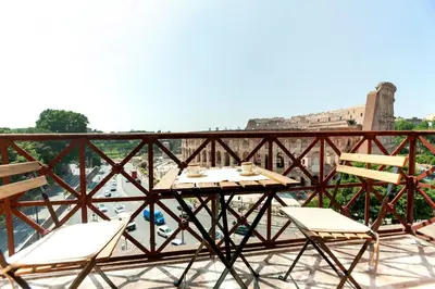 a table and chairs on a balcony with a view of the city at Roma Colosseo, vista da sogno in Rome
