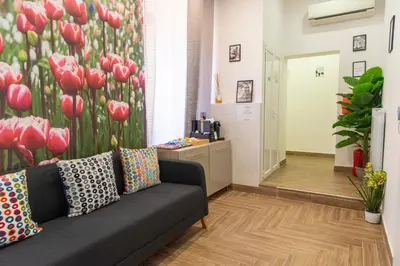 a living room with a couch and red tulips mural at Susys's Guest House - Room Castel Sant'Angelo in Rome