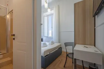 a small room with a bed and a table at Residenza Degli Speziali Roma Prati in Rome