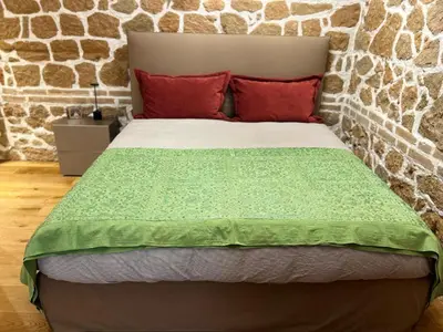 a bed with a green comforter and red pillows at Luxury Loft near Via Veneto in Rome
