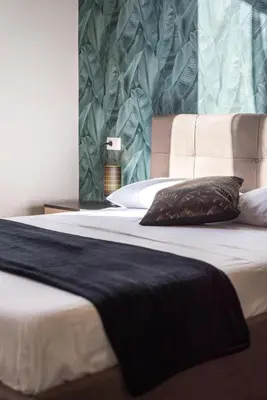 a bed with a black blanket on top of it at Roma Design Rooms San Giovanni Colosseo Area in Rome