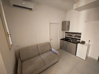 a living room with a couch and a kitchen at Appartamento Alida in Rome