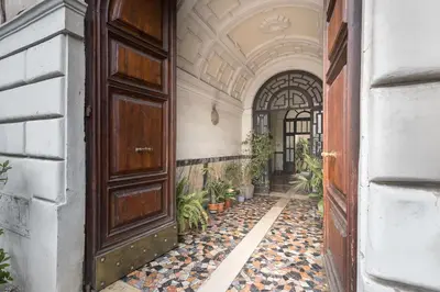 an empty hallway with a large wooden door and potted plants at Vista Laterana in Rome
