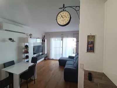 a living room with a table and a clock on the wall at Pato's Home - Appartamento Condiviso Con Parcheggio Gratuito in Rome