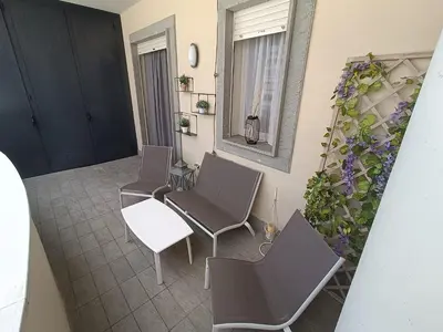 a patio with three chairs and a table and a mirror at Pato's Home - Appartamento Condiviso Con Parcheggio Gratuito in Rome