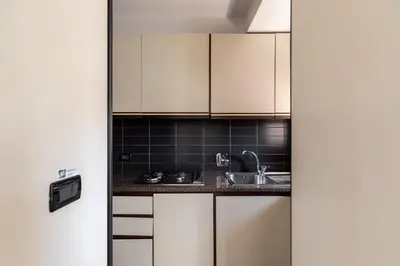 a kitchen with white cabinets and a sink at Celeste Retreat al Pantheon - Homkeey Apartments in Rome