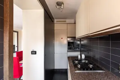 a kitchen with white cabinets and black tiles at Celeste Retreat al Pantheon - Homkeey Apartments in Rome