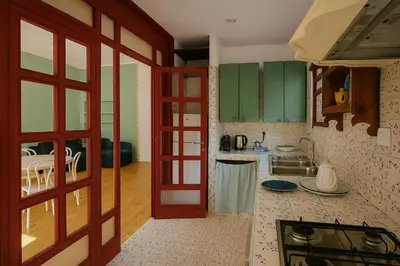a kitchen with green cabinets and a counter top at Aurelio APT - Homkeey Apartments in Rome