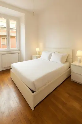 a white bedroom with a white bed and two windows at Aurelio APT - Homkeey Apartments in Rome