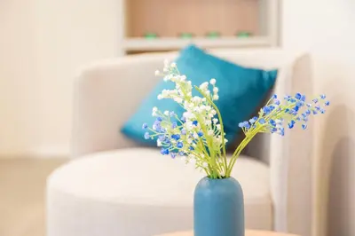 a blue vase with blue and white flowers on a table at imperium suite trevi in Rome