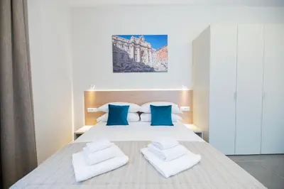 a bedroom with a bed with blue and white pillows at imperium suite trevi in Rome