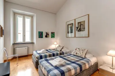 a bedroom with two beds and a couch at Rosa Trastevere Magic Location in Rome