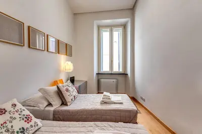 a bedroom with two beds and a window at Rosa Trastevere Magic Location in Rome