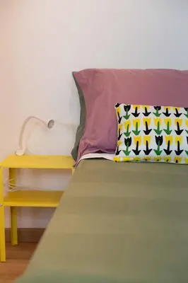 a bed with a pillow and a side table at La casetta nascosta in Rome
