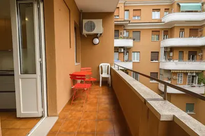 a balcony with red chairs and a building at -Colosseum 15 Min -Trastevere, Free Wi-Fi and A-C in Rome