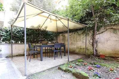 a table and chairs under an umbrella in a garden at Bologna Garden House in Rome