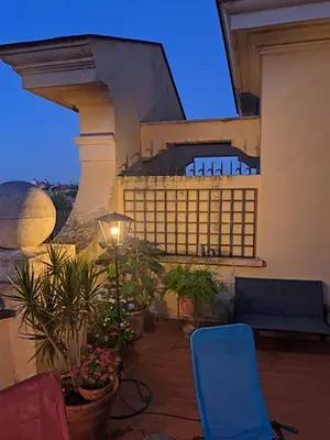 a balcony with chairs and plants on a building at Terrazza Trastevere Apartment in Rome