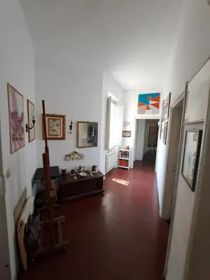 a living room with white walls and a red floor at Terrazza Trastevere Apartment in Rome
