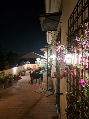 an outdoor patio at night with tables and chairs at Terrazza Trastevere Apartment in Rome