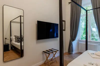 a bathroom with a mirror and a tv on a wall at Castro Pretorio 9 - FromHometoRome in Rome