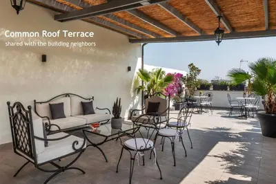 a patio with chairs and tables and a couch at Castro Pretorio 9 - FromHometoRome in Rome