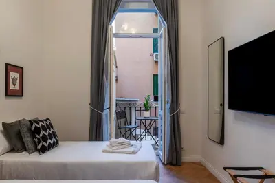a living room with a white couch and a window at Castro Pretorio 9 - FromHometoRome in Rome