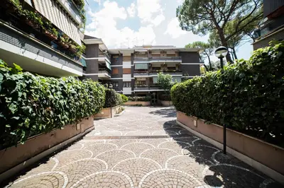 a walkway in front of a building with bushes at VaticanRhome II in Rome