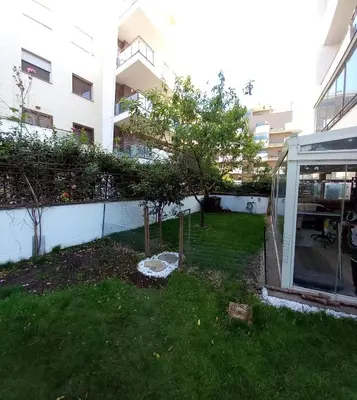 a garden with a tree in the middle of a building at Bilocale EUR Grotta Perfetta 50mq casa 32mq sala hobbies e 250mq giardino in Rome