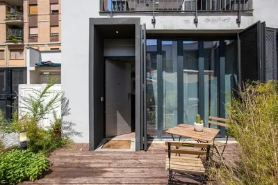 an open door of a building with a wooden table at Cottage with Garden and Terrace near Termini in Rome
