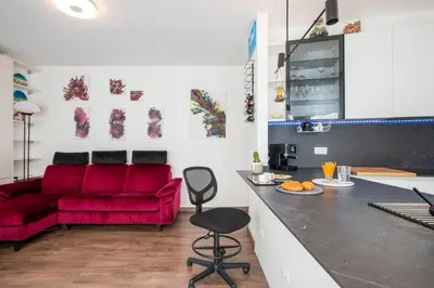 a living room with a red couch and a kitchen at Cottage with Garden and Terrace near Termini in Rome