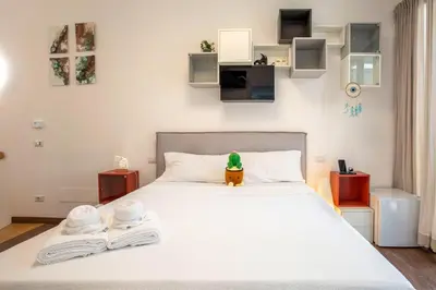 a bedroom with a large white bed with two towels at Cottage with Garden and Terrace near Termini in Rome