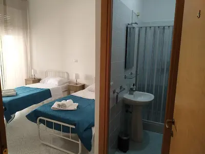 a bathroom with two beds and a sink and a shower at Trionfale Guest House in Rome