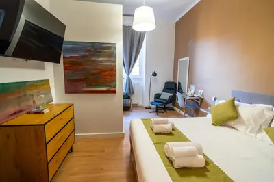 a bedroom with a large bed and a tv at NOI Luxury rooms Colosseum in Rome
