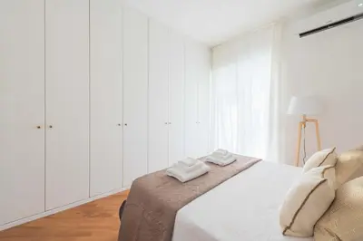 a white bedroom with a bed with two towels on it at SuityRHome San Giovanni 11 in Rome